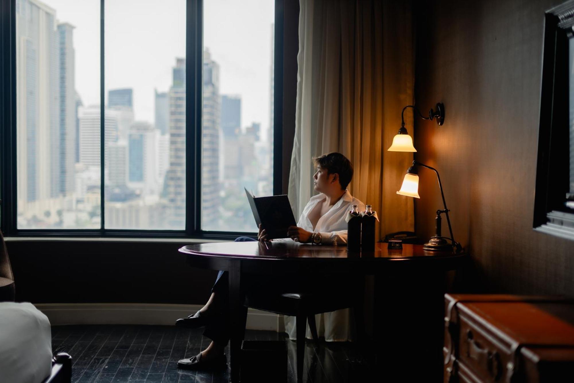 Hotel Muse Bangkok, Autograph Collection Esterno foto A man working in a hotel room